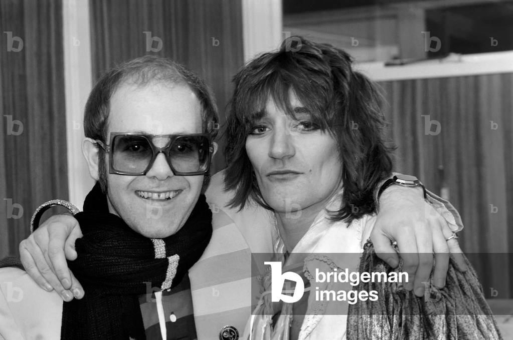 Rod Stewart and Elton John. Pop superstars Rod Stewart and Elton John make it up back stage at Olympic tonight just before Rod went on stage for the third night of his series of London concerts, December 1976 (b/w photo)