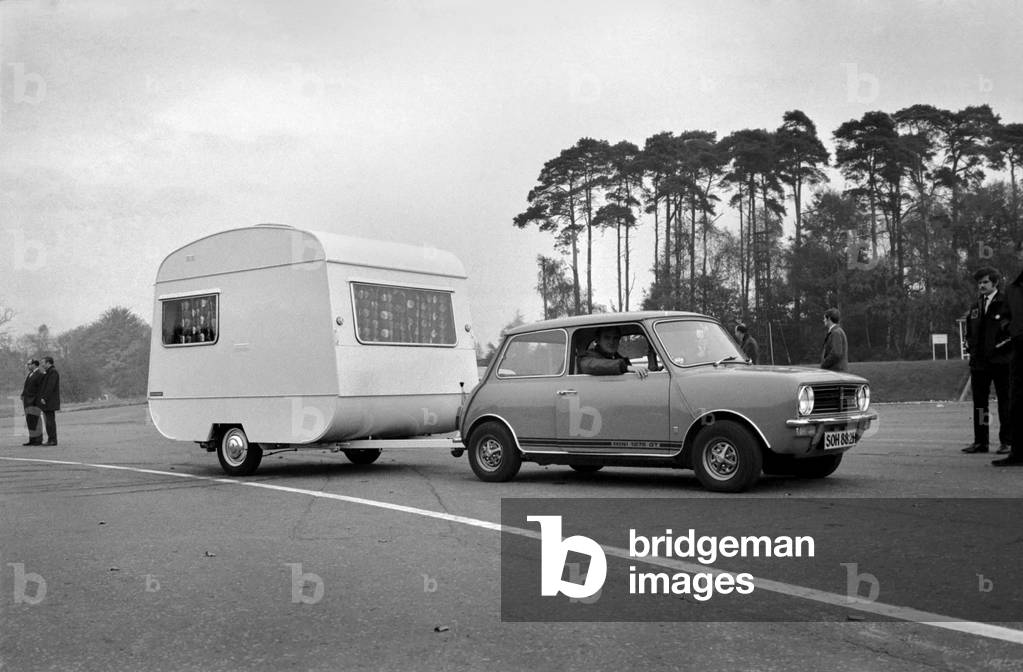 A caravan being towed by a mini clubman car. 
November 1969