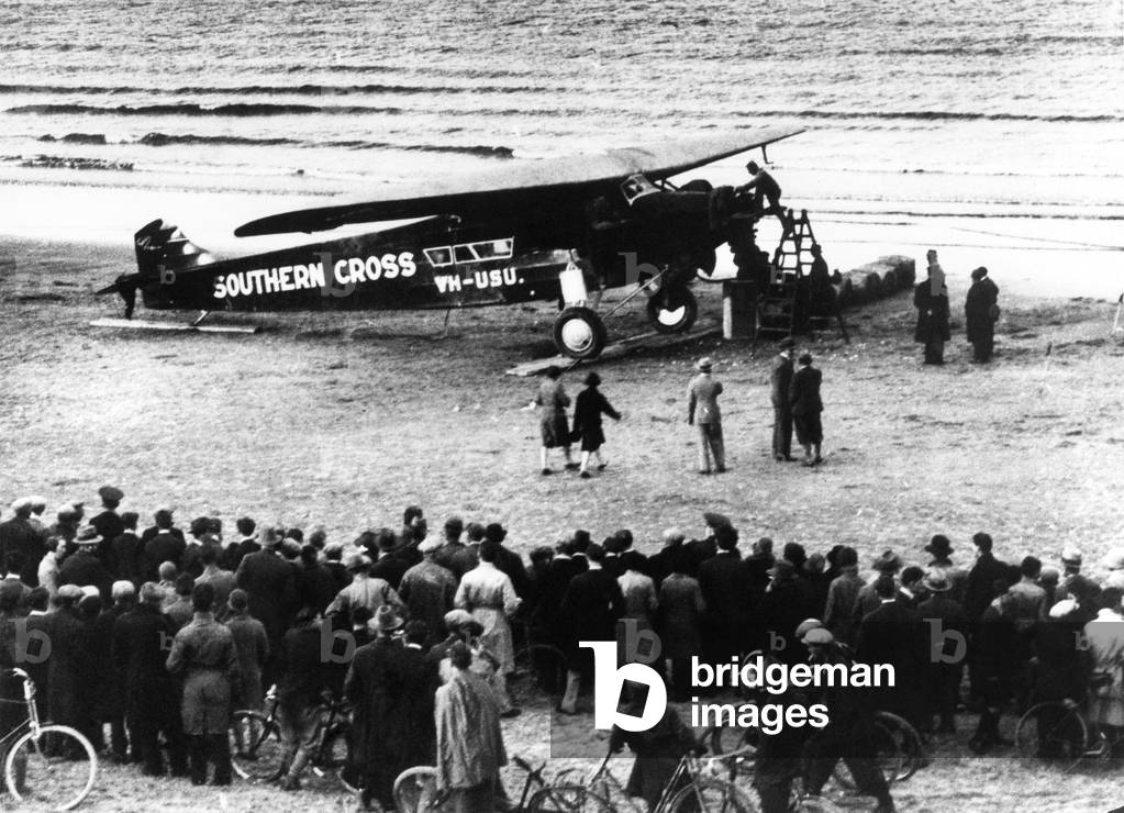 Flying from Ireland to U.S.A. At dawn (June 24th) Major Kingsford Smith, the famous Australian airman, took off in the Southern Cross, from Portmarnock near Dublin with three companions, hoping to reach New York this evening. If all goes well he intends to proceed to San Fransico, and son complete a round-the-world flight in his famous monoplane. The Southern Cross surrounded by a crowd before the start. June 1930