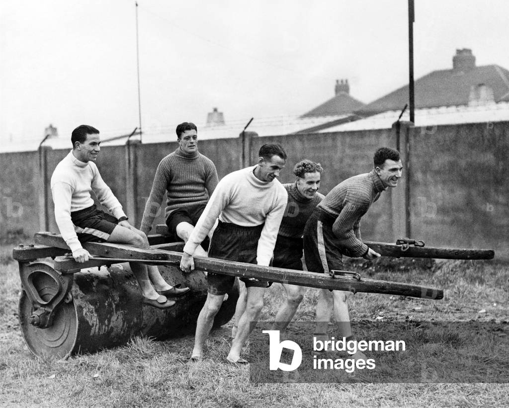 Left to right. Robledo, Whyte, Pallister, Normanton and Kitchen lend a hand with the roller at Fleetwood F. C. ground where Barnsley F. C. are preparing for their cup tie with Manchester City. January 1948 (photo)