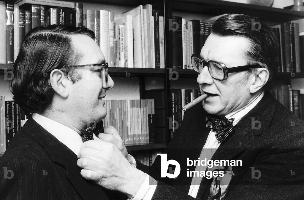 Sir Robin Day Tv Presenter and Broadcaster adjusts the polka dot bow tie of Peter Callan former Daily Mirror Newspaper Reporter, 07/09/1979 (b/w photo)