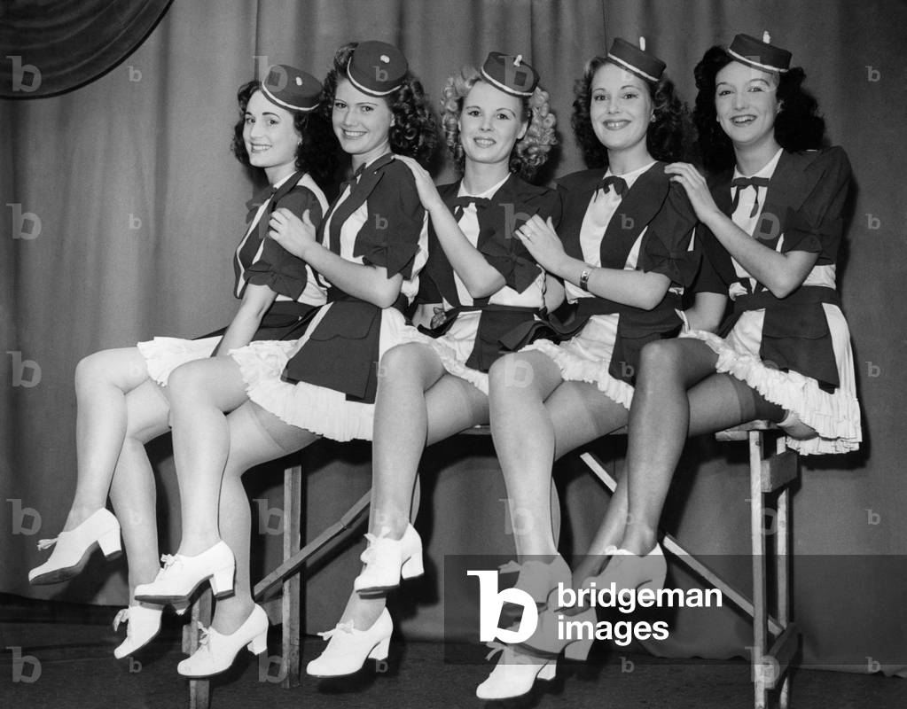 Clothing Stockings. These girls love their work. Left to right. Jean Hammond, Joan Daniels, Kathleen Wright, Winnie Arnell and Pat Burdett wearing the stockings at the dance this evening. September 1947 P018462