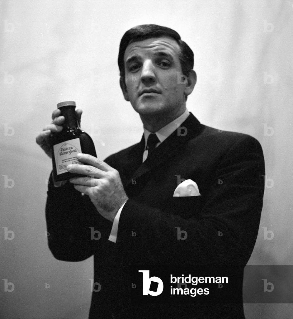 Radio DJ Alan Freeman holding a bottle of Mersey water
February 1964