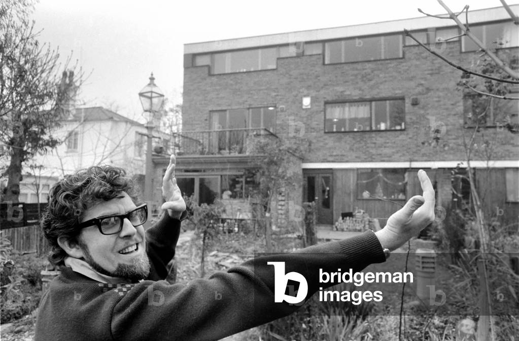 Singer Rolf Harris who lives in Sydenham, Kent, has bought the house adjoining his own modern terrace. He decided he would like to enlarge the three bedroomed house and knocked down the brick wall between the houses, himself. Rolf and his sculptress wife Alwen live their with their five year old daughter Bindi. RRolf Harris showing the exterior of the house. December 1969