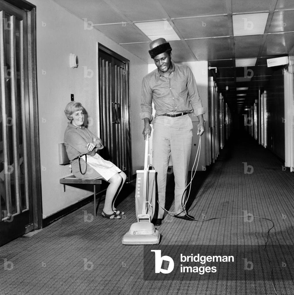 Charley Polite arrived in London from Springfield U.S.A., and immediately held a press conference at his London Hotel re, his next Tuesday, 9th December, Albert Hall clash with British heavyweight prospect Joe Bugner. Polite by name, polite by nature, Charlie takes over hoovering chores watched by a grateful chambermaid. November 1969