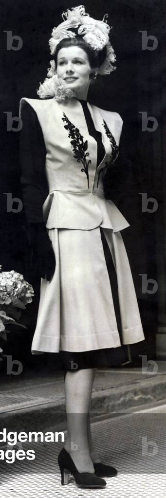 Fashion Parade - Four-way idea in clothes shown at Mayfair Hotel. Palin black wool frock with hidden blue sequined belt with flaring three-quarter length skirt slit up the front and a sleeveless bolero top with a small peplum decorated on each breast with a design of black sequins, June 1946 (b/w photo)