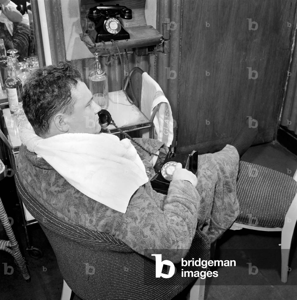 Actor and singer Harry Secombe seen here ordering and then eating a meal order from the Romains Buttery and delivered by Scooter to his dressing room, 1959 (b/w photo)