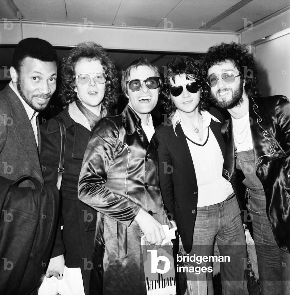 Pop Star Steve Harley and the Cockney Rebel Pop Group at Heathrow Airport today after their arrival from New York, 26th February 1975 (b/w photo)