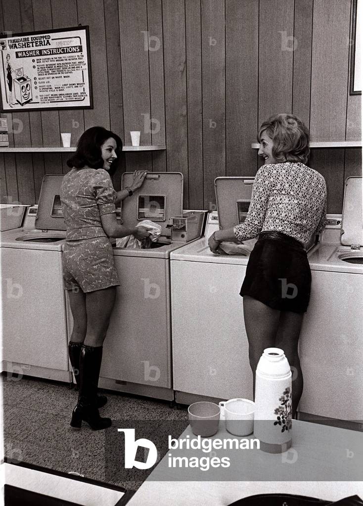 Women in a laundrette - Housewives Brenda and Carol in hotpants doing the washing, April 1971