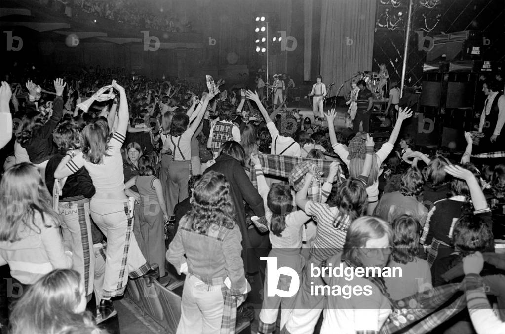 Fans cheer as the Bay City Rollers perform on stage at Cardiff, May 1975 (b/w photo)