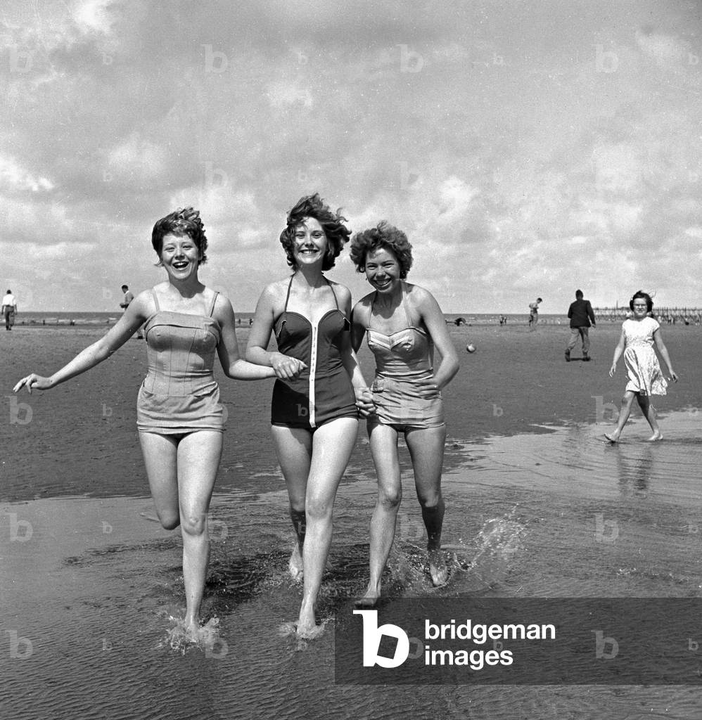 Girls in swimsuits running on the beach at Blackpool, 5th August 1958 (b/w photo)