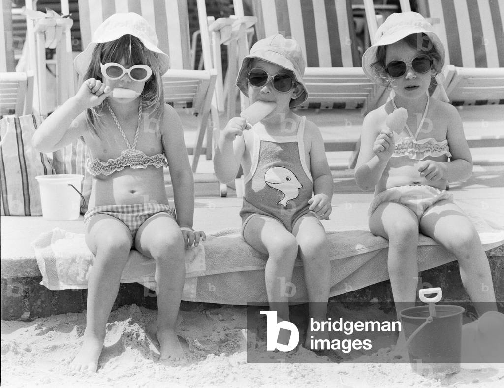 Three young girls sitting on the beach, enjoying an ice lolly, 26th June 1979 (b/w photo)