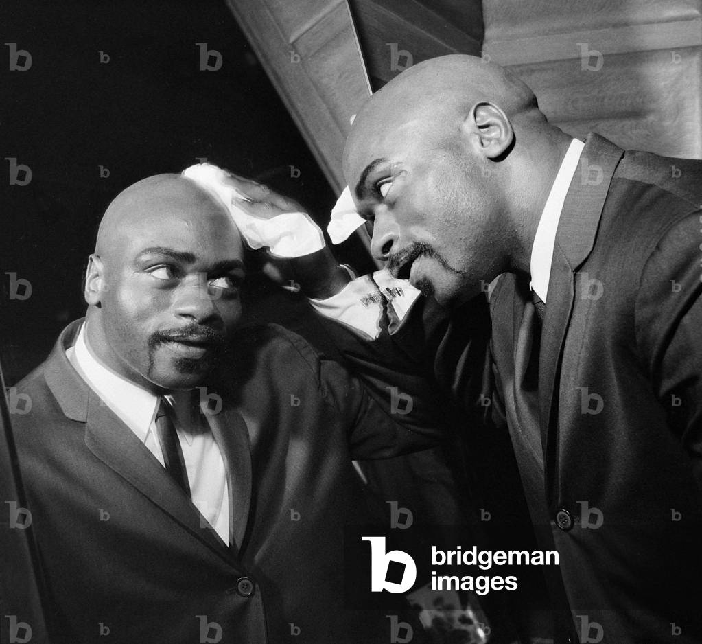 American middleweight boxer Rubin Hurricane Carter of New Jersey, USA, mops his head as he mops it after a wash and brush up in the barber shop of his London hotel before his fight with Tony Scott at the Royal Albert Hall. February 1965
