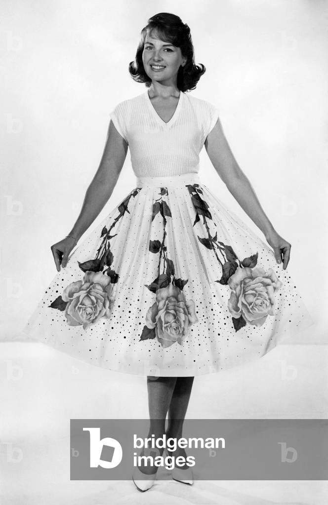 Woman wearing top and long patterned skirt. July 1959