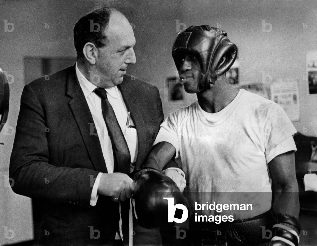 Lennox Beckles, Guyana champion, in Manchester getting ready for his fight for Johnny Cooke's Empire title, has his gloves put on by Laurie Lewis, who is staging the fight at the Liverpool Stadium, on Monday Oct. 16th. November 1967