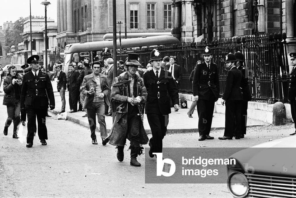 A top-hatted hippie is led away by a policeman at the end of the battle. 22nd September 1969.