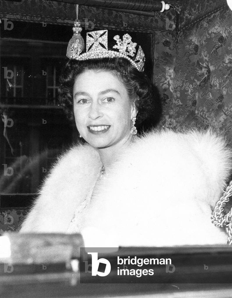 Queen Elizabeth II smiles at cameraman as she left the quadrangle of Buckingham Palace in the Irish coach on her way to open Parliament, 31st October 1967 (b/w photo)