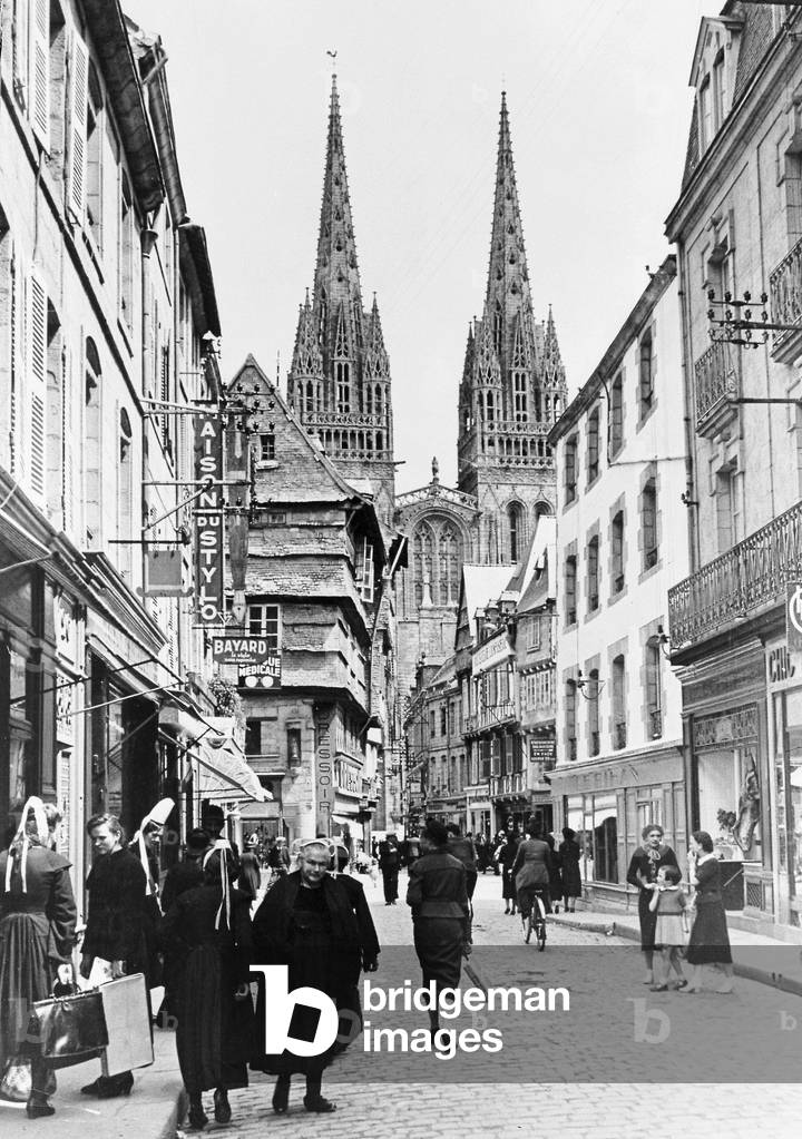 A street scene in Quimper with the cathedral overlooking the town in the background 1930s, Quimper, Brittany, France, 1938 (b/w photo)
