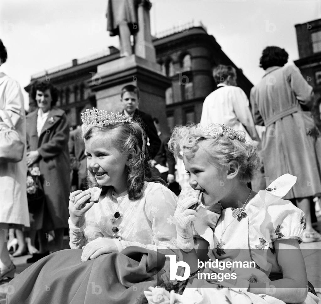 Whit Walks Manchester: After waiting for such a long time these two kiddies decided on a pavement snack before starting in the walks. They are Left Janice Litster aged 10 and her cousin Georgina Litster aged 7. June 1960