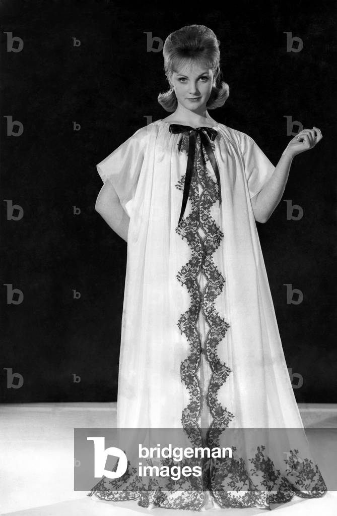 Reveille Fashions: Roma Reeves modelling full length night dress, May 1960 (b/w photo)