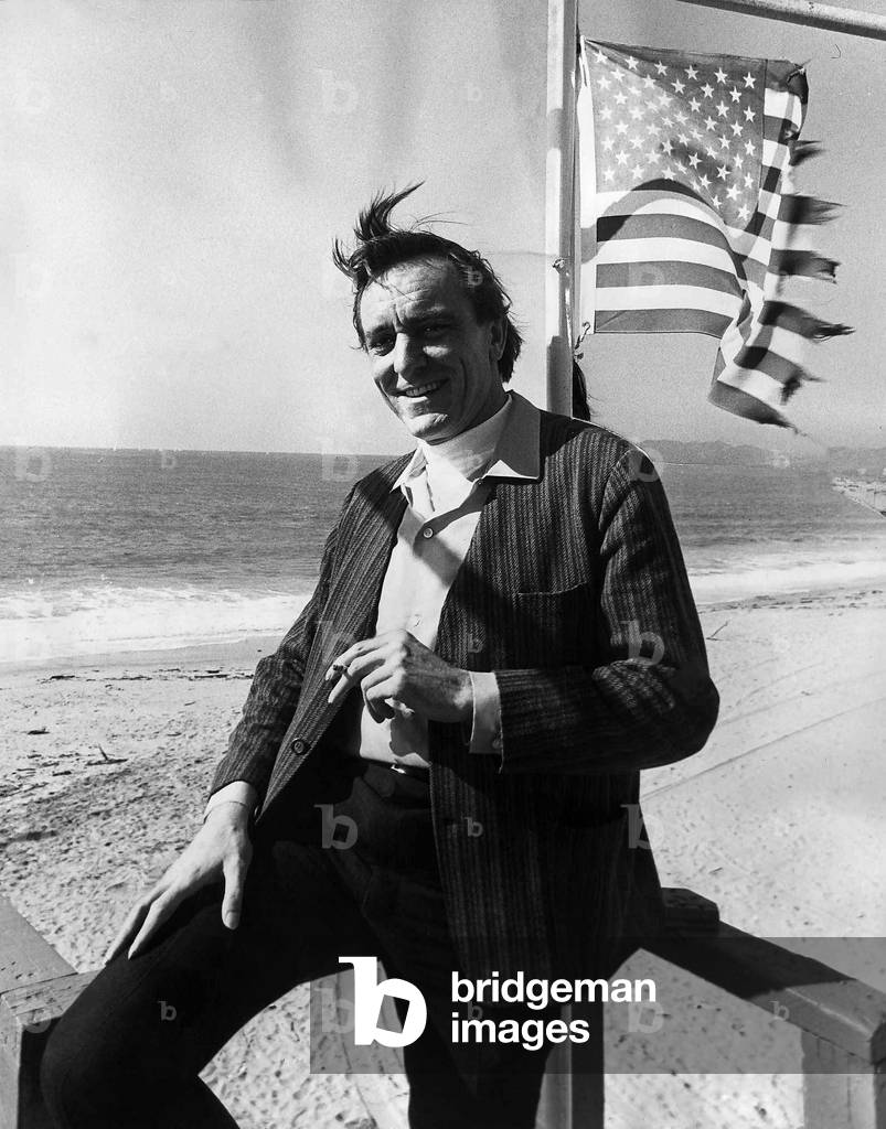 Eric Porter British actor standing on a beach under the American Flag, 1969