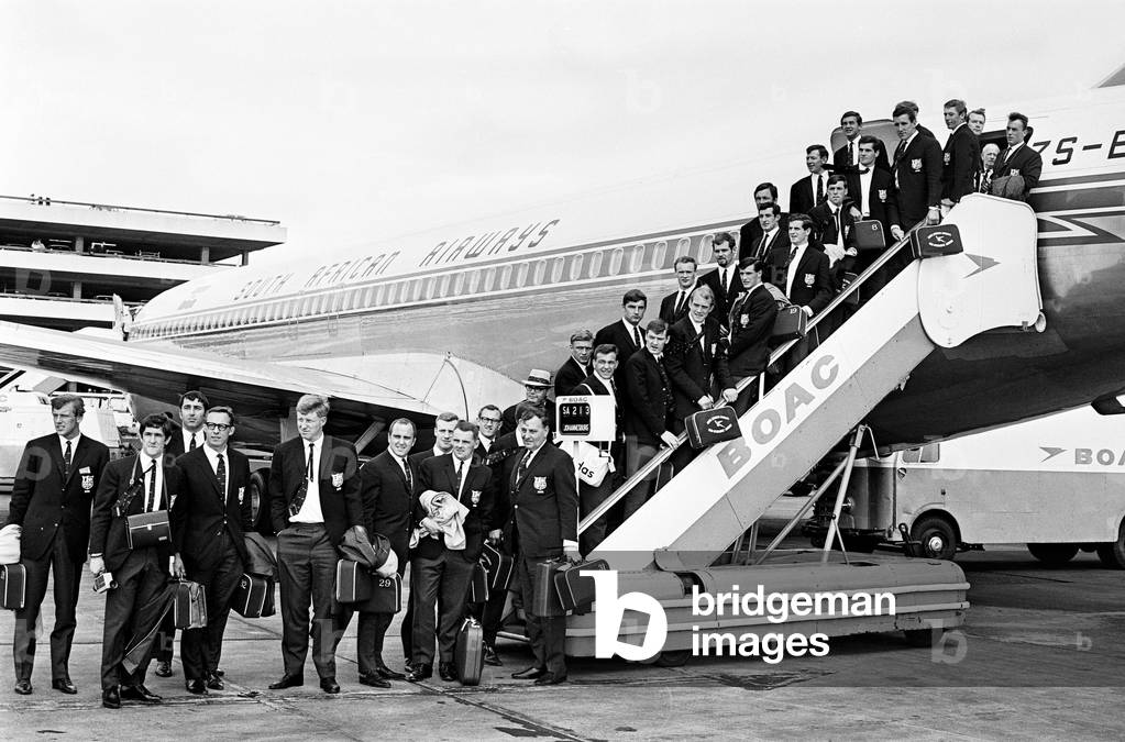 The British Lions rugby union team pose on the steps of their plane before leaving for South Africa. 12th May 1968 (b/w photo)