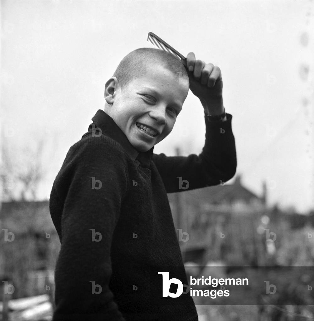 Gary Brown, 14, of St. Mary's Street, Winchester, who was sent home from the Montgomery of Alamein School, Winchester, because he had his hair cut too short, March 1975 (b/w photo)