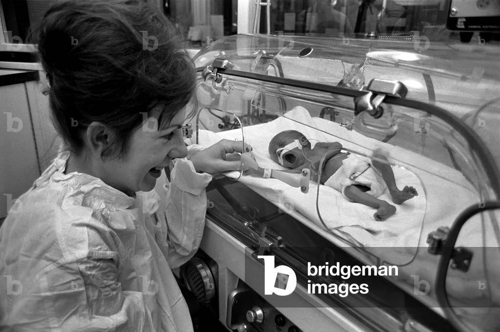 Medical. Mrs. Rosemary Letts holds baby Cara for the first time in the incubator at University College Hospital, after she gave birth to quintuplets. December 1969