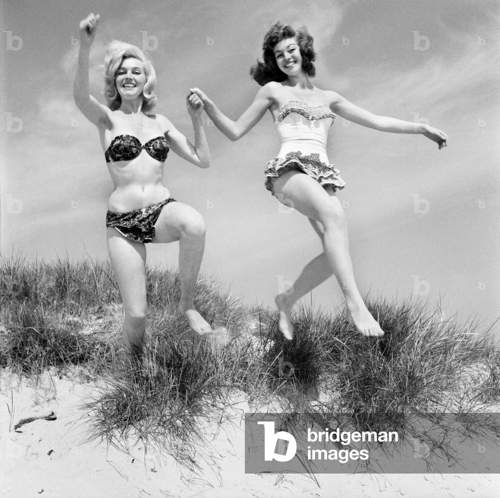 Glamour girls Marion and Jean Collins on the beach. June 1960