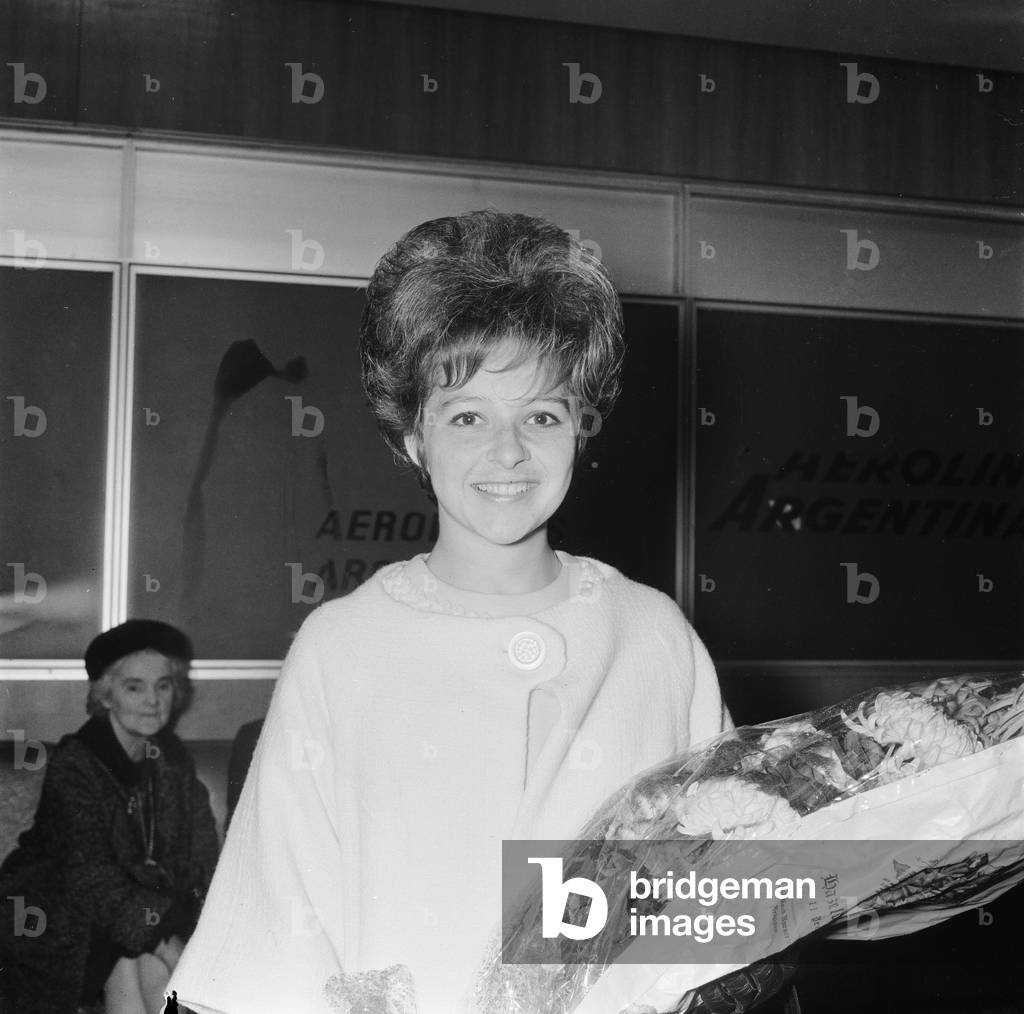 American pop singer Brenda Lee smiles upon arrival at London airport, before her appearance in the Royal variety Show. 1st November 1964 (b/w photo)