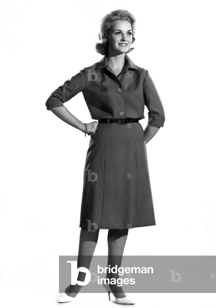 Model Roma Reeves wearing long dress, standing with hands on hips. October 1961