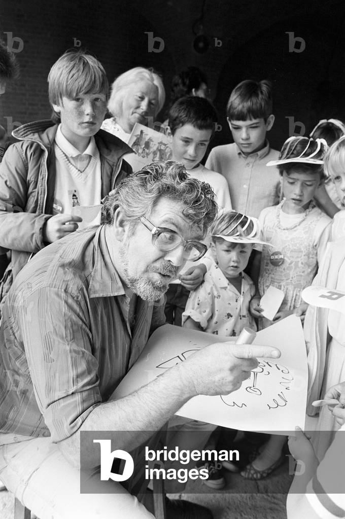 Rolf Harris, drawing sketches as he entertains children at Albert Dock, Liverpool, 13th July 1986 (b/w photo)