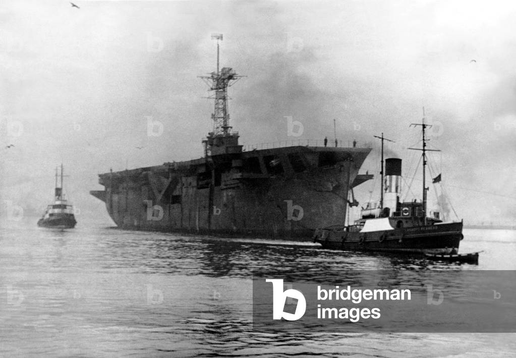 The aircraft carrier HMS Vindex arriving at the River Tyne from Rosyth on her way to her moorings at Jarrow. She was to be re-converted into a fast cargo liner and renamed 'Port Vindex', 4th October, 1947 (b/w photo)