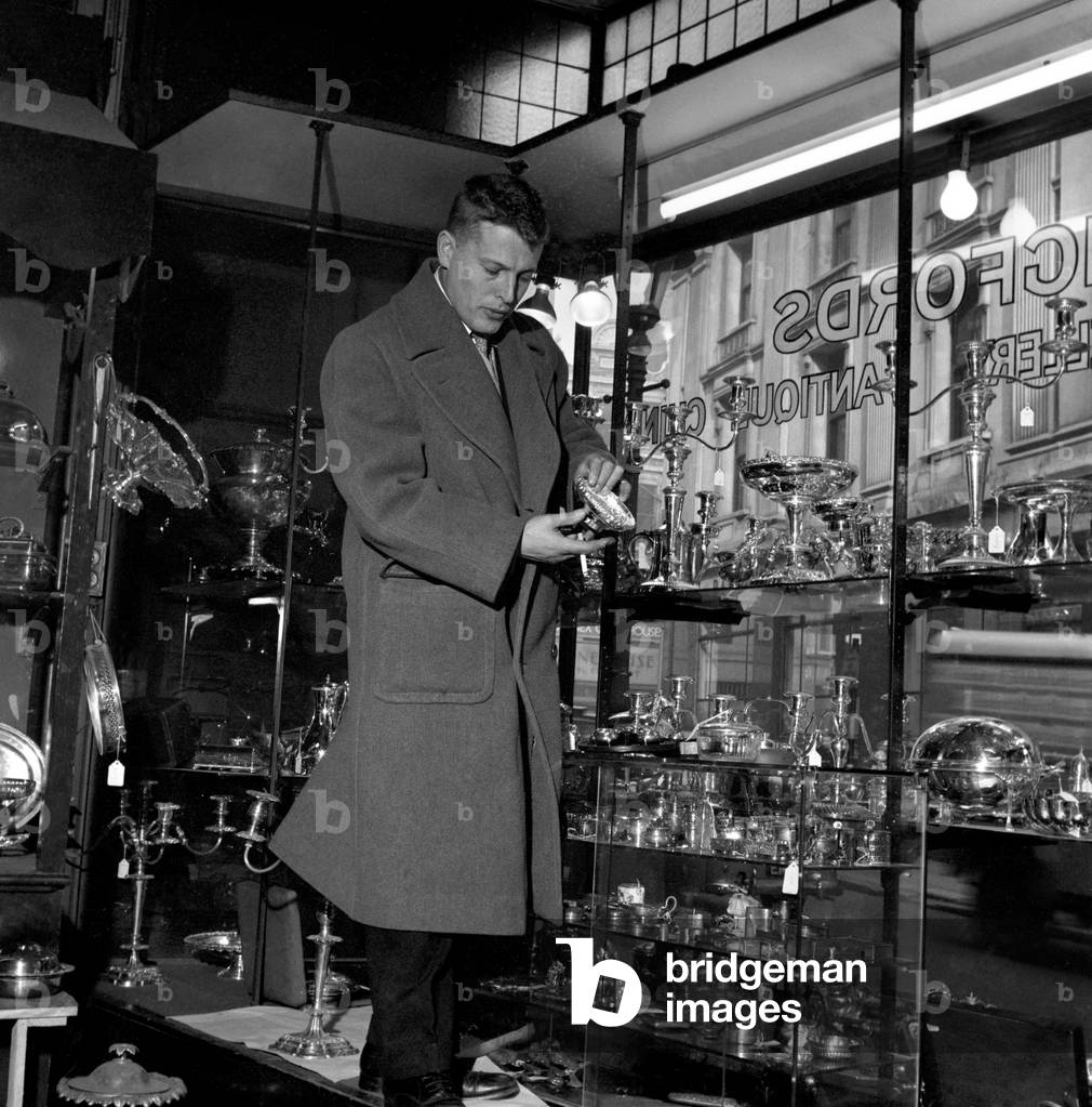 Below Chancery Lane hidden away behind large safe doors, the London Silver Vaults house a seemingly endless number of specialist silverware dealers. There is a massive range of goods, from candelabras and cutlery to fine jewellery. Our picture shows: Silversmiths at work in the Silver Vaults of London, December 1956 (b/w photo)
