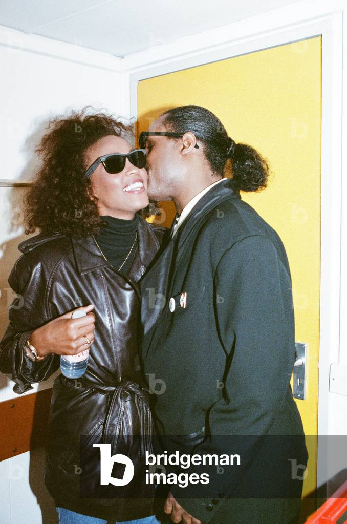Stevie Wonder kisses Whitney Houston on the cheek as they laugh backstage at the Nelson Mandela Concert in London on 11th June 1988.