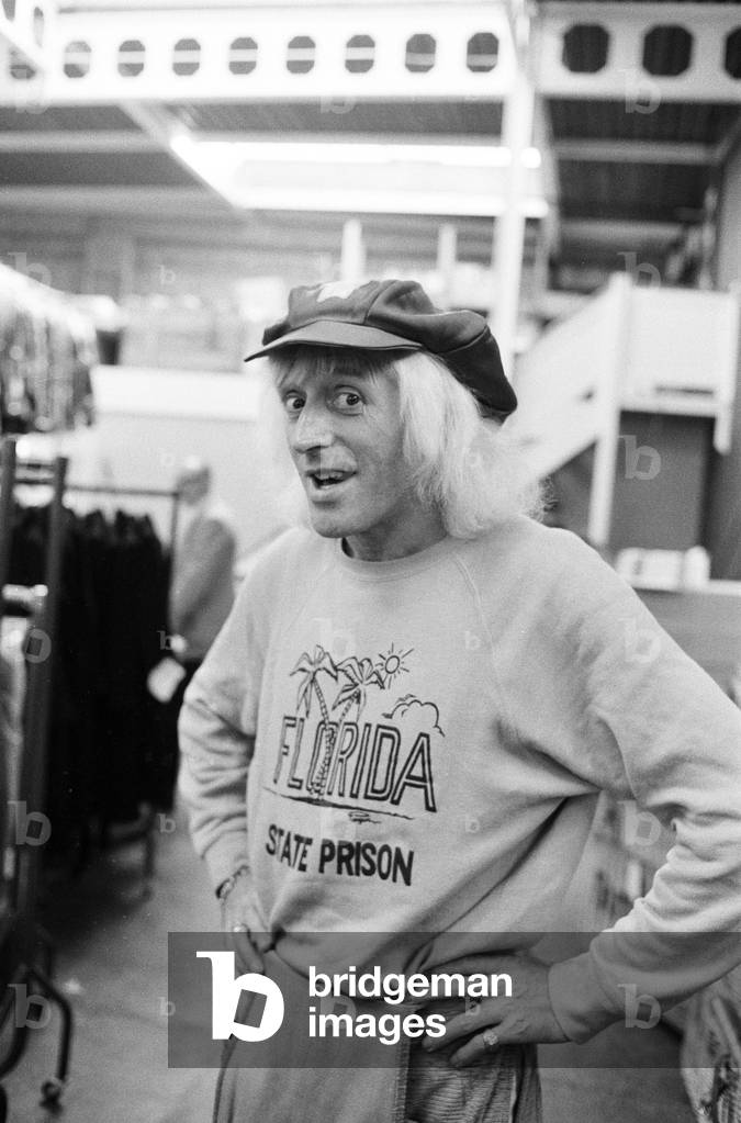 A day in the life of Jimmy Saville' Feature by Mike Hellicar. Here he is pictured trying on an outfit at Lord John warehouse in Acton, 7th October 1971 (b/w photo)