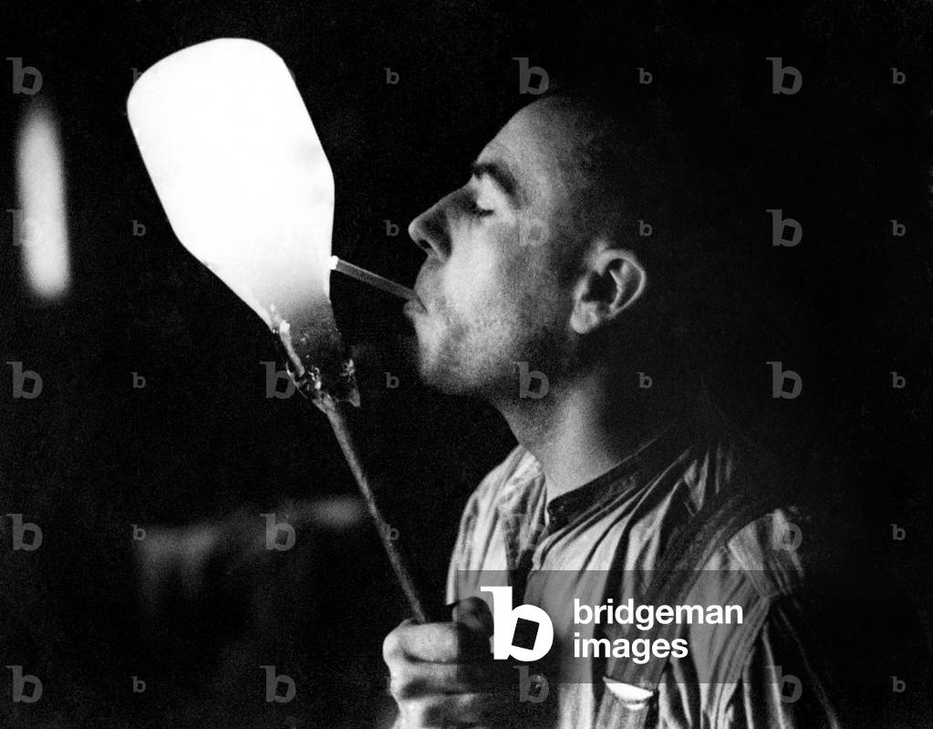 Glass workers never use matches, he just places his 