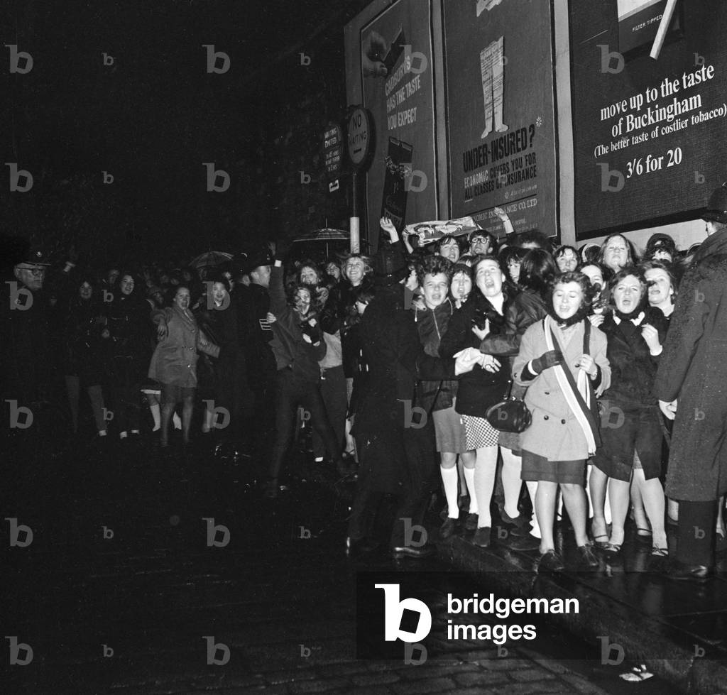 Fans meet The Beatles in Liverpool, queuing up outside for the show, 6th December 1965 (b/w photo)