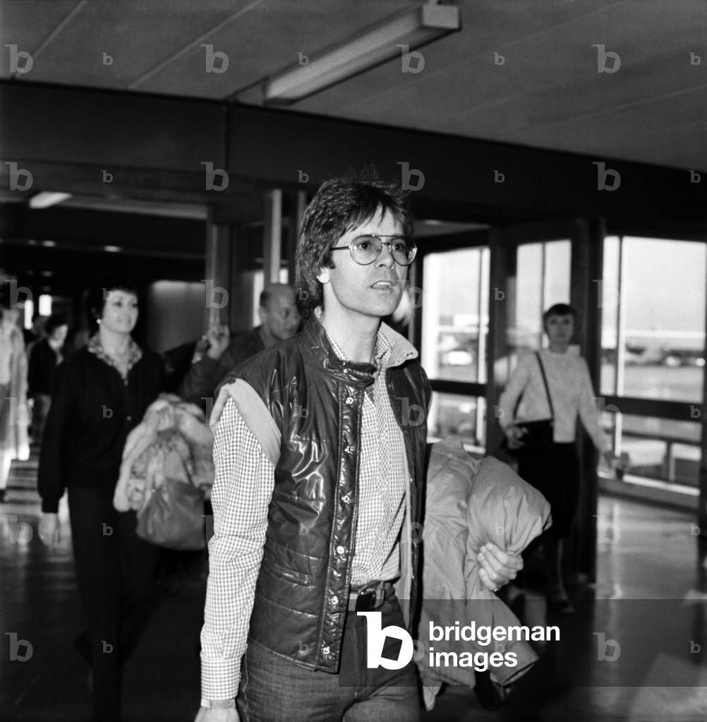 Departure of pop singer Cliff Richard flying to Los Angeles to make preparations for his next tour of U.S.A. his first tour in 17 years also to promote his latest record A Little in Love, January 1981 (b/w photo)