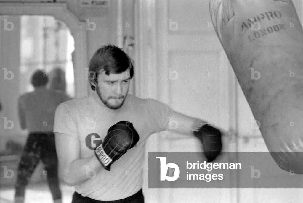 British and European Welterweight Champion John H. Stracey complete with beard at work in the 'Royal Oak' gym Canning Town, March 1975 (b/w photo)