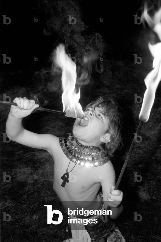9 year old fire eater Tony Walls. Tony at his Fire Swallowing Act, December 1976 (b/w photo)