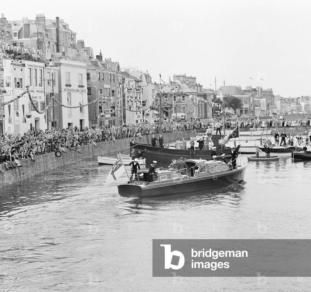Crowds await the arrival of Her Majesty Queen Elizabeth II at St Peter Port in Guernsey on her royal visit to the Channel Islands with her husband Prince Philip, Duke of Edinburgh.
29th July 1957.
