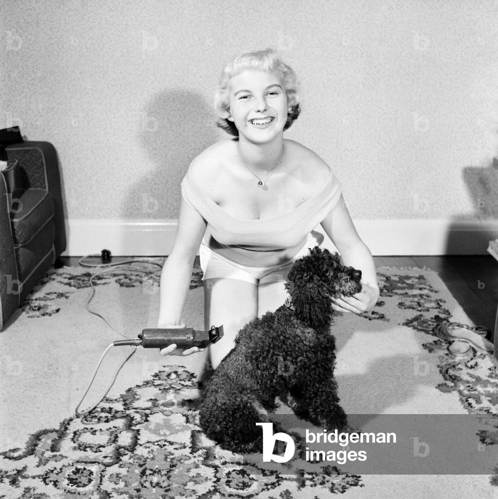 Pat Bolton seen here with her pet poodle dog, 1964 (b/w photo)