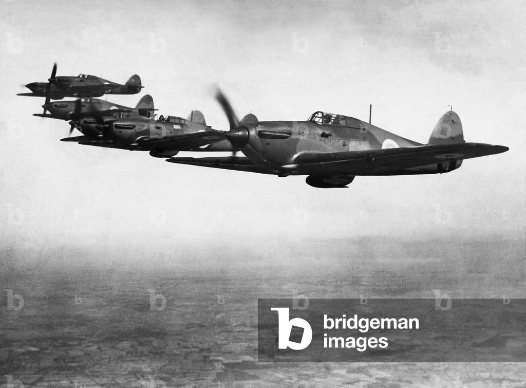 Six RAF early Hawker Hurricane MK1 fighter aircraft with two blade fixed pitch propellors in flight over England, c. August 1937 (b/w photo)