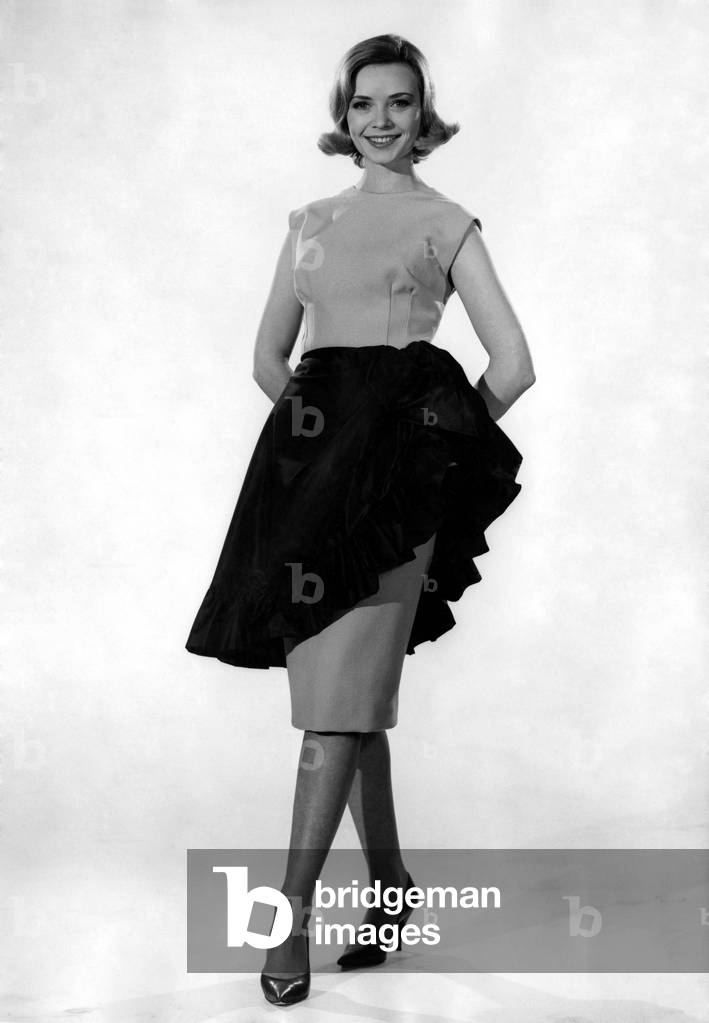 Model Sarah Browne wearing sleveless tio with long skirt. April 1961