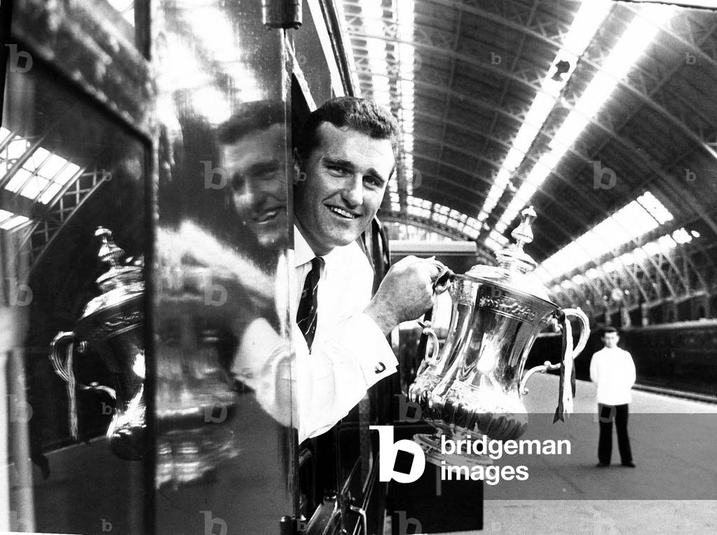 Manchester United captain Noel Cantwell leaning from the train with the FA cup trophy at Saint Pancras station on the way back to ManchesterMay 1963 (photo)