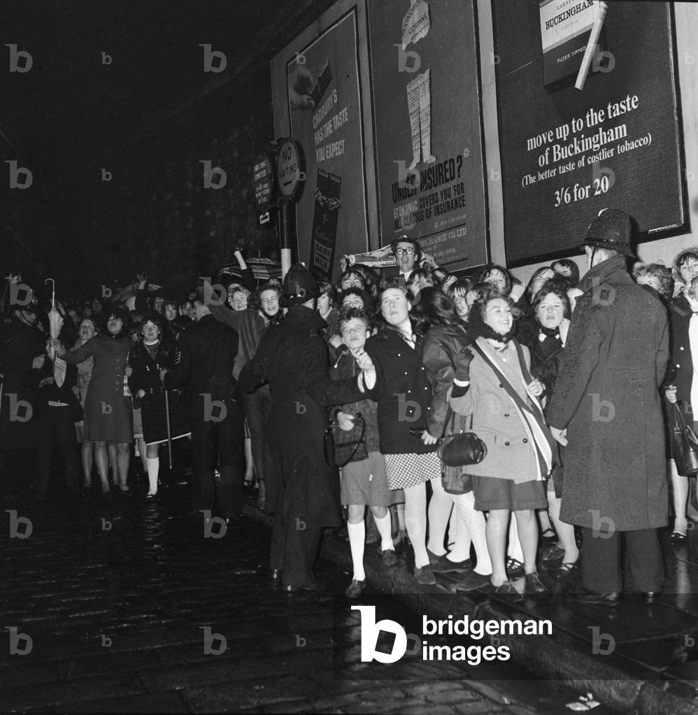 Fans meet The Beatles in Liverpool, queuing up outside for the show, 6th December 1965 (b/w photo)