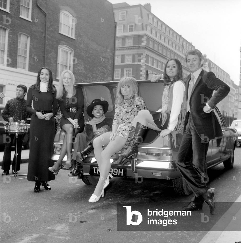 Glamour: Pirelli Limited have produced yet another of their famous calendars for 1970. They will have printed 43,000 calendars which will be distributed to their tyre dealers and footwear agents. Today at the Europa Hotel they held a press conference to launch the new calendar and invited Piers Courage the racing driver to post with some of their model girls. Piers Courage with five of the models who appear in the Pirelli calendar who are left to right Anak of Singapore, Anne Hanson of London and Pegga St. Helen of St. Lucia and Jo Wade from Surrey, Jaleh Haddad from Persia. December 1969