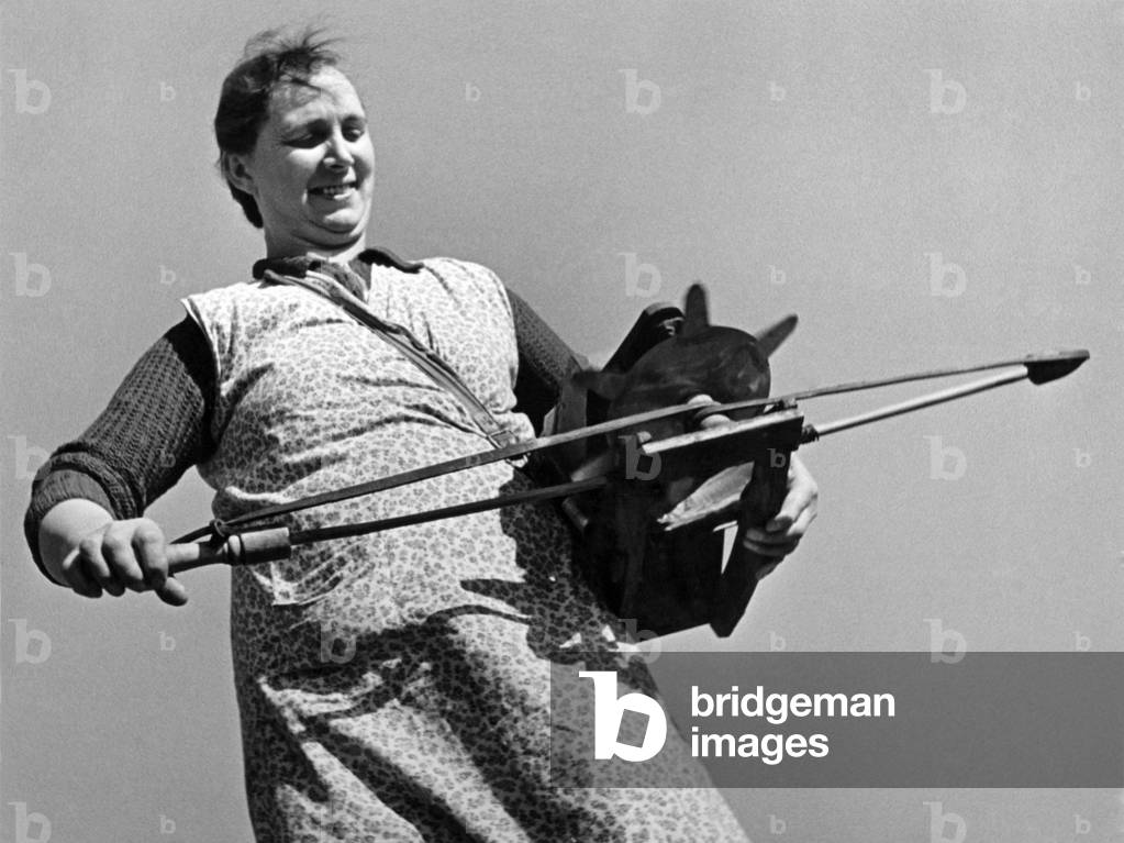Mr. John Watson of Ryburgh, near Fakenham, Norfolk Farm has taught his wife to sow seeds with the old fashion fiddle or broadcaster, this helps to solve the man power shortage. It is possible to sow 20 acres with these instruments which fling the seeds three yards, Pictures show the farmer and his wife, She is learning to sow hay seed with her husband. March 1948