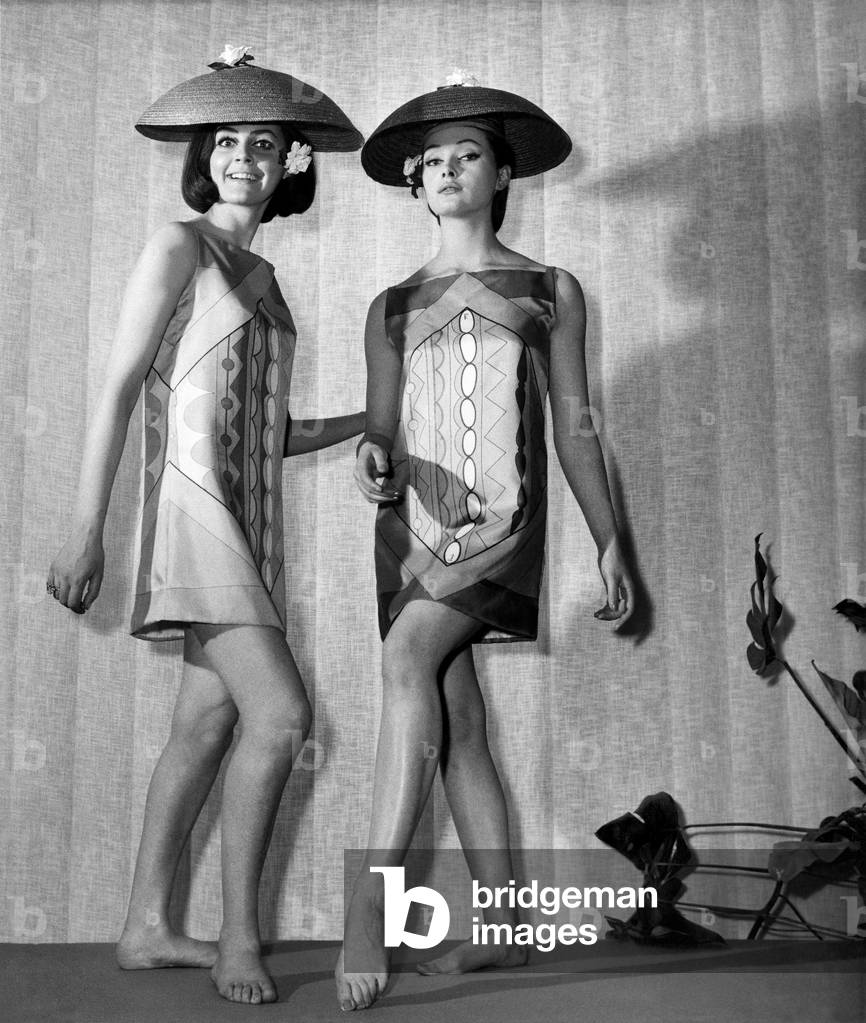 Clothing Beach. Two women model patterned mini dresses and lampshade-shaped hats on stage.